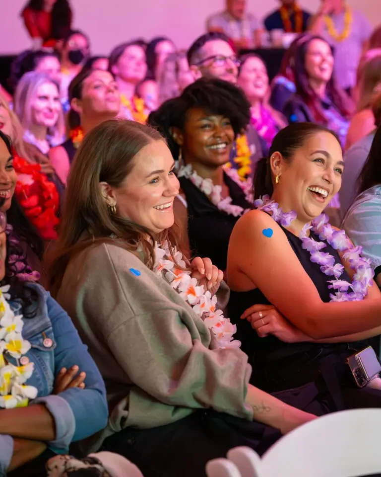An audience at a pitch night laughing and watching the stage